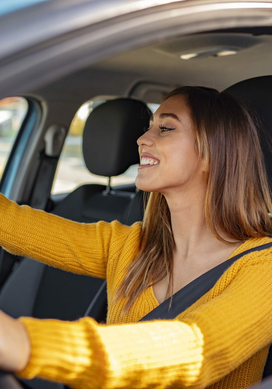 Beautiful female Driver adjusting the Rear Mirror looking at herself. Adjusting the rear view mirror. Woman adjusts the rear view mirror with her hand. Happy young woman driver looking adjusting rear view car mirror